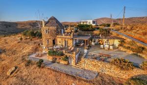 an old stone house in the middle of a field at The Stone Windmill in Koundouros