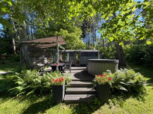 a wooden deck with a table and chairs and flowers at Citi Krasti Eco Spa Residence in Kārļzemnieki