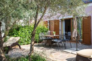 a patio with a table and chairs and an umbrella at Istria Sea Side Apartments Lina in Labin