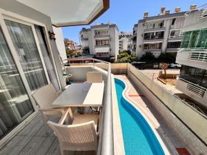a balcony with a table and chairs and a swimming pool at Alanya polat tatil evleri in Alanya