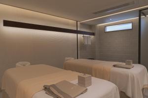 a room with two beds and a mirror at Craftsman Bangkok in Bangkok