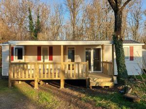 a small house with a porch and a deck at Camping du Nizour in Sireuil