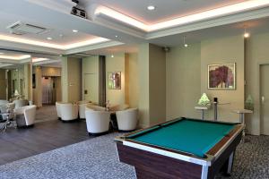a room with a pool table and chairs at The Originals Boutique, Hôtel Les Strélitzias in Juan-les-Pins