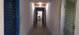 a hallway with blue and green doors and a tile floor at Hotel Montreal in Abadiânia