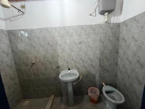 a bathroom with a toilet and a sink at Hotel Montreal in Abadiânia