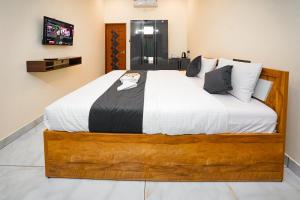 a bedroom with a large bed with white sheets and pillows at Uni Stay Inn in Cochin