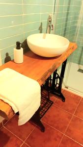 a bathroom sink on a wooden table with towels at Casa Rural La Changa in Losar de la Vera