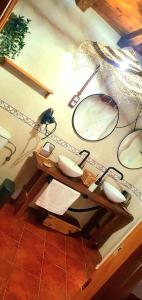 a bathroom with two sinks and two mirrors on a wall at Casa Rural La Changa in Losar de la Vera