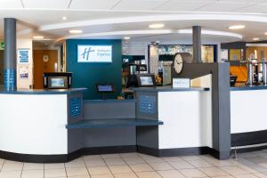 a counter in a store with a clock on it at Holiday Inn Express Stafford by IHG in Stafford
