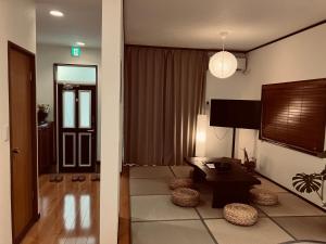 a living room with a table and a tv at HOUSE26 Private Villa near Green Expo Yokohama in Machida