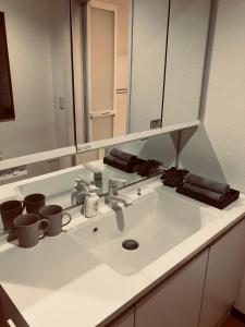 a white bathroom sink with a large mirror at HOUSE26 Private Villa near Green Expo Yokohama in Machida +16 photos