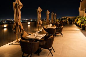 a restaurant with tables and chairs on a balcony at night at Twin Burj Hotel in Nouakchott