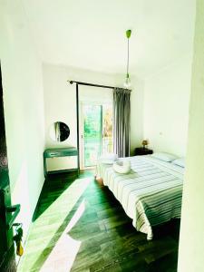 a bedroom with a large bed and a large window at Chambre du jardin in Rabat