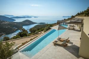 a swimming pool with chairs and a view of the ocean at Villa Symposium Infinity in Sivota