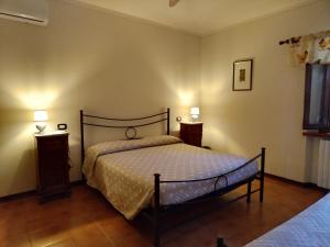 a bedroom with a bed with two night stands and two lamps at Da Poldino in Borgo a Buggiano