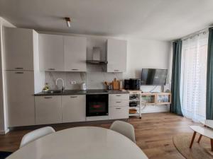 a kitchen with white cabinets and a table at Villa apartment Laganini in Okrug Gornji