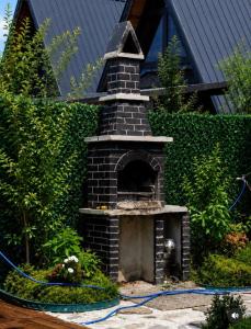 a brick fireplace in a garden in front of a house at Altınkum Bungalov in Dereköy