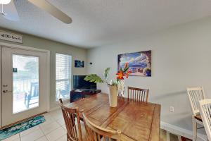a dining room with a wooden table with a vase of flowers at Grand Caribbean Perdido Key #306 West in Perdido Key