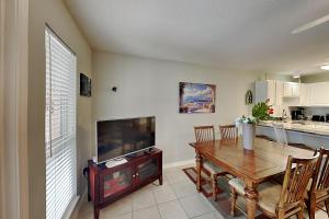 a kitchen and dining room with a table and a television at Grand Caribbean Perdido Key #306 West in Perdido Key