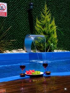 a pool with a plate of fruit and two glasses of wine at Altınkum Bungalov in Dereköy