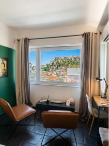 a room with a desk and a large window at Elite Ermou Suites in Athens