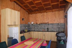 a kitchen with a table and a refrigerator and a table and chairs at Lake House Mantasoa in Mantasoa +36 photos