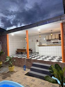 a patio with a checkered floor and orange columns at Casa Calleb in Presidente Figueiredo