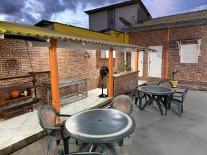 a patio with tables and chairs and a brick building at Casa Calleb in Presidente Figueiredo