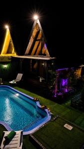 a swimming pool in front of a house at night at Altınkum Bungalov in Dereköy +4 photos