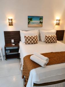 a hotel room with two beds with towels on them at Pousada Galemares in Maragogi