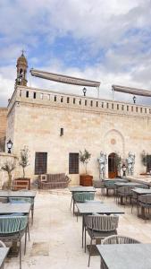 a courtyard with tables and chairs in front of a building at Konak Zenobia in Midyat