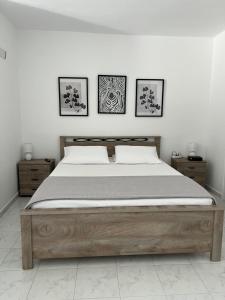 a bed in a bedroom with three pictures on the wall at Costelia Studio in Ialysos