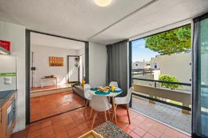 a living room with a table and chairs on a balcony at Hakuna Matata House in Alvor