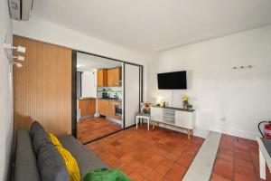 a living room with a couch and a table with a television at Hakuna Matata House in Alvor