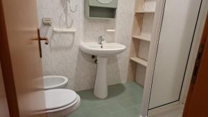 a small bathroom with a toilet and a sink at Costadeiapartments in Briatico