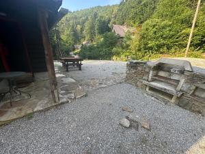 a bench sitting next to a stone wall with a table at Palčkov oddih in Škofja Loka