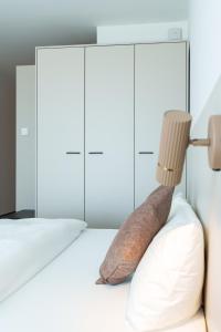 a bed with a pillow and a lamp on it at Boardinghouse Air Tech Campus - smart Check-in in Weßling