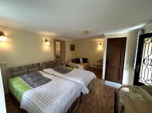 a bedroom with two beds and a living room at Guest House Panda in Kutaisi