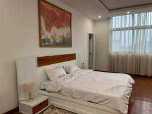 a bedroom with a white bed and a large window at 19&G Apt in Addis Ababa