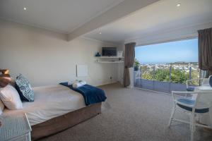 a bedroom with a bed and a large window at Dockside in Port Alfred