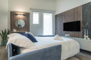 a bedroom with a large bed and a television at GuestHost - Vivaldi Inverno Apartment in Treviglio +8 photos