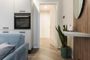 a living room with a blue couch and a kitchen at GuestHost - Vivaldi Inverno Apartment in Treviglio