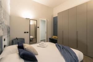 a bedroom with a white bed with a mirror at GuestHost - Vivaldi Inverno Apartment in Treviglio