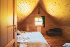 a bedroom with a bed and a couch in a attic at Domek na Górkach in Krościenko