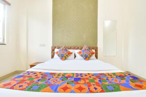 a bedroom with a bed with a colorful quilt at FabHotel Tiru Rooms in Pune