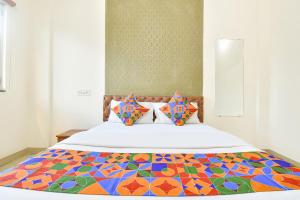 a bedroom with a bed with a colorful quilt at FabHotel Tiru Rooms in Pune