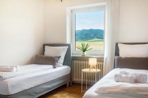 two beds in a room with a window at Hesselberg-Oase Ferienhof Hüttner in Röckingen