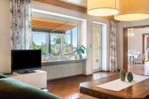 a living room with a tv and a large window at Hesselberg-Oase Ferienhof Hüttner in Röckingen