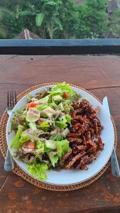 a plate of food with a salad on a table at Double view point sibetan in Tenganan