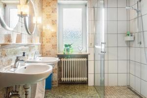 a bathroom with two sinks and a window and a radiator at Hesselberg-Oase Ferienhof Hüttner in Röckingen +30 photos